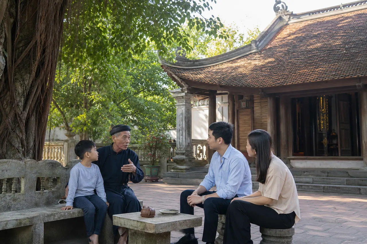 Người lớn tuổi trong làng đang chỉ cho một gia đình trẻ vị trí ban thờ và nhịp đứng lễ trong sân đình buổi sáng