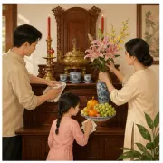 Hai người lớn và một bé gái chăm bàn thờ gỗ có hoa, chén gốm và trái cây
