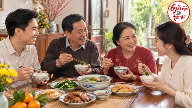 Bốn người lớn cầm bát cơm trò chuyện quanh bàn ăn có món rau và canh