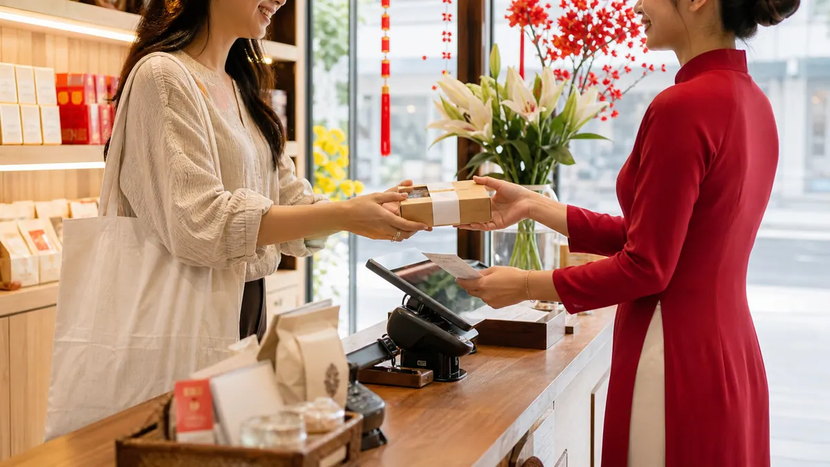 Chủ cửa hàng trao sản phẩm cho khách trong giao dịch mở hàng đầu tiên